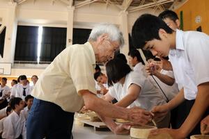 西郡さんから滝瓦作りを学ぶ生徒の写真