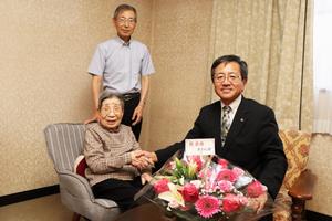 100歳を迎える高齢者と家族と市長の写真