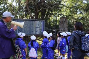 御山で話を聞く児童たちの写真