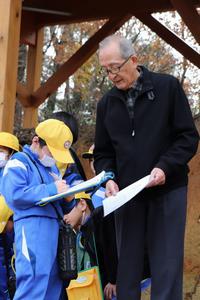 たたら製鉄遺跡保存会会長から話を聞く児童の写真