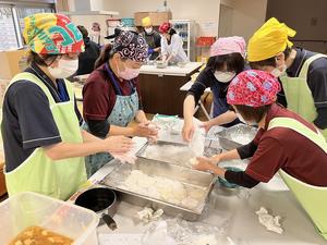 職員がお餅を切り取る画像