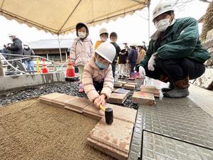 石を敷き詰める園児の画像