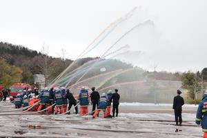 カラフルな水を一斉放水する消防団