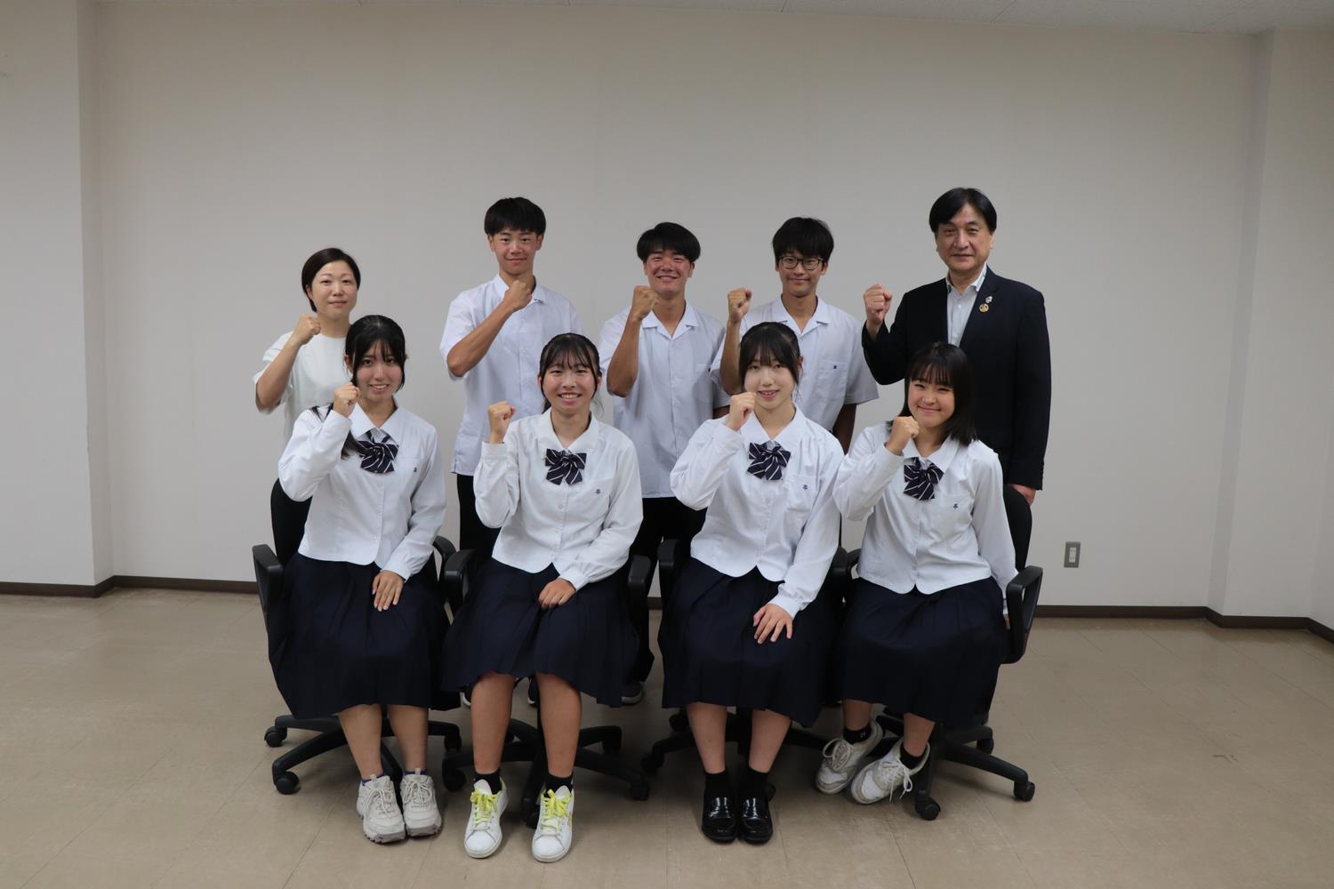 ガッツポーズで記念撮影する高校生たち
