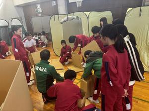 段ボールベッドを組み立てる児童たち