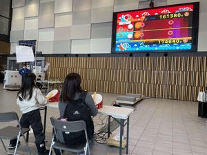 大型ビジョンに映る太鼓の達人を楽しむ様子