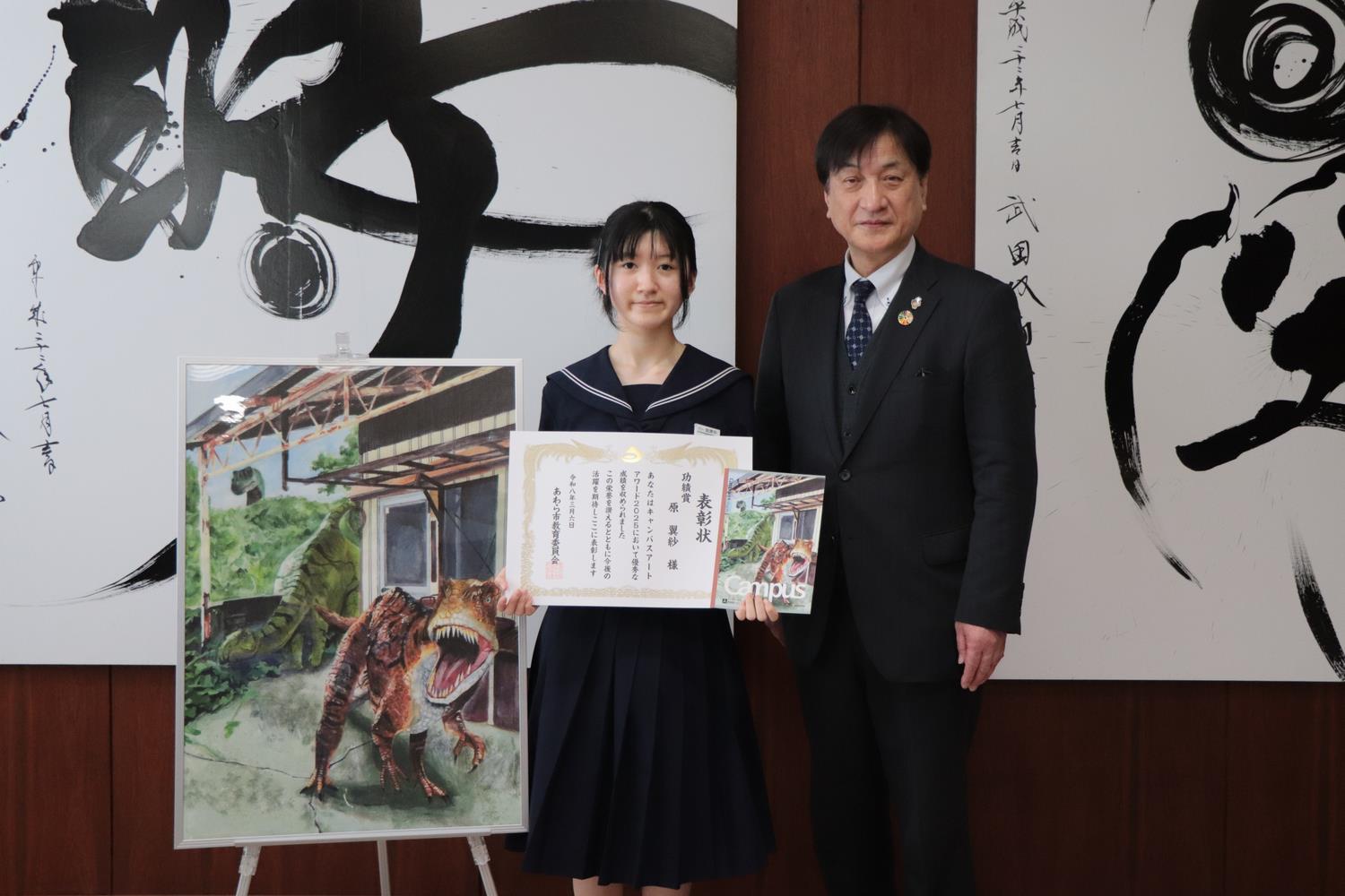 授賞作品がデザインされたノートを持つ原さん