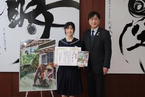 授賞作品がデザインされたノートを持つ原さん