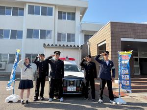 パトカーの前で敬礼をする生徒たち