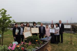 花壇の周りで集合写真を撮る様子