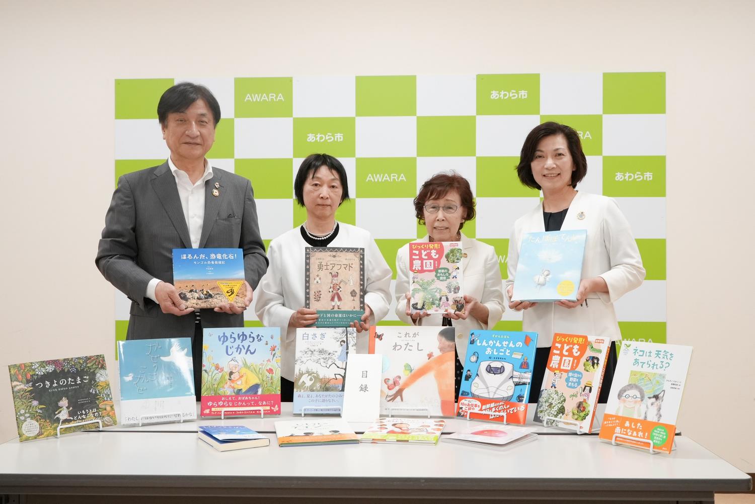 絵本を持って記念撮影する様子